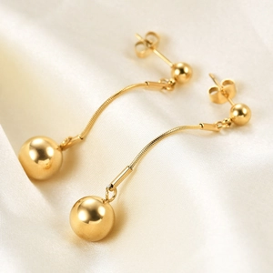 Minimalist 18K gold drop earrings with double ball spheres and snake chain on satin