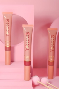 Three glossy cushion lip gloss tubes in nude pink on a professional geometric display