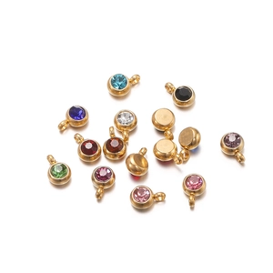 Close-up of golden stainless steel pendants with vibrant colorful zircon gemstones