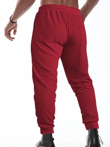 Detail of red waffle knit joggers showing back pocket and elastic waistband texture