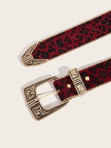 Detail of red leopard print belt with gold engraved buckle and beaded metallic edges