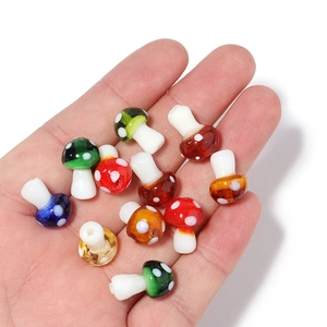 Hand holding colorful glass mushroom beads showing the scale for DIY jewelry making