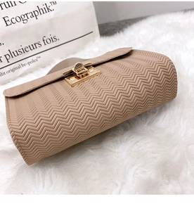 Detailed view of apricot wavy embossed leather and golden square metal twist lock closure
