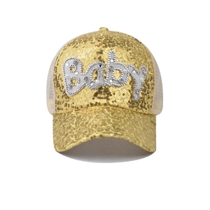 Détail du patch Baby et des paillettes dorées sur la casquette trucker en mesh