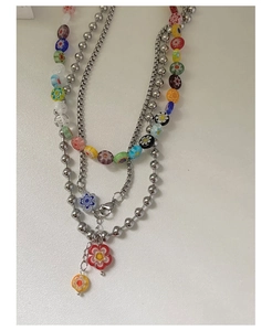 Détail du collier multi-rangs Y2K avec pendentifs fleurs en verre coloré et perles argentées