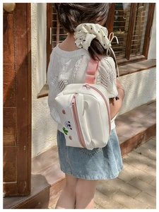 Detail view of white PU crossbody bag with cute bear and heart on a child model back