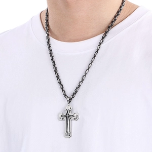 Detail of multi-layered cross pendant with black oil drip on Byzantine chain necklace