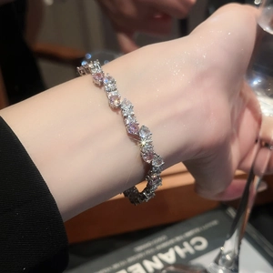 Macro shot of silver twisted bracelet set with pink and white sparkling zircons