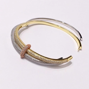 Three-tone interlocking cuff bracelet with micro-pave crystals in gold and silver finish