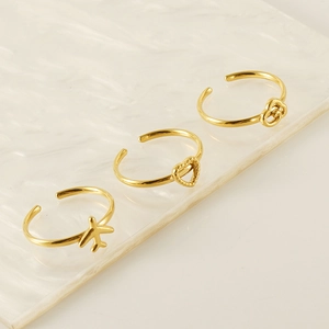 Three-piece set of gold adjustable rings featuring airplane, heart, and knot designs