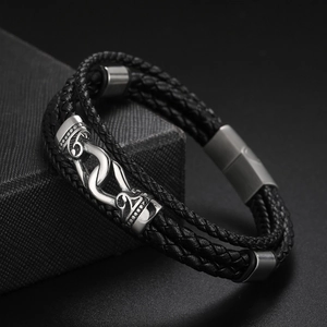 Détail d'un bracelet multicouche en cuir noir avec boucle argentée sur coffret