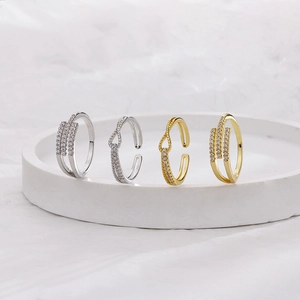 Detail of silver and gold knotted S925 rings with zircon crystals on a white tray