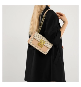 Gros plan sur un sac à main beige en cuir avec rabat géométrique et bandoulière dorée