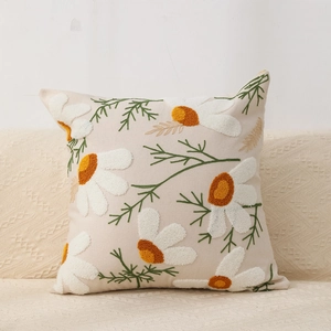 Bohemian beige tufted pillow cover with white daisy embroidery on a sofa cushion