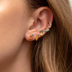Detailed view of gold fruit-shaped earrings with colorful zircon stones on person ear