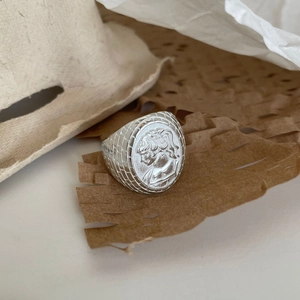 Detail view of oval 925 silver ring featuring a vintage portrait cameo and textured band