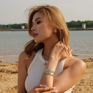 Set di gioielli in oro 18K con occhio del diavolo, malachite verde e zirconi sulla spiaggia