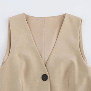 Dettaglio del gilet kaki con scollo a V, trama del tessuto fine e bottone nero