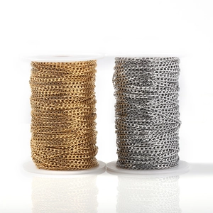 Flat stainless steel Cuban link chains in gold and silver finish on white spools