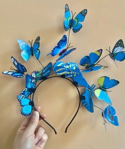 Close-up of vibrant blue 3D butterfly headband with layered wings for festive parties