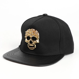 Détail d'une casquette hip-hop avec crâne en métal doré et visière à motif serpent