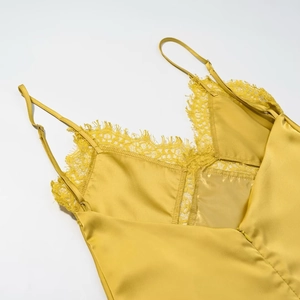 Detail of yellow satin camisole with delicate lace trim along the neckline and strap