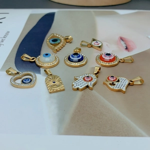 Detail of diverse gold evil eye charms with rhinestones and resins on a magazine page