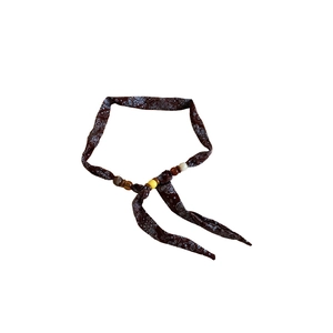 Ethnic paisley fabric necklace with colorful wooden beads on a white background