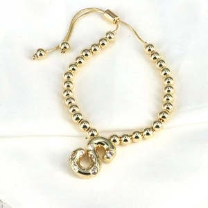 Adjustable gold beaded bracelet featuring a sparkling zircon-encrusted letter S charm