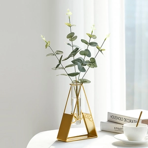 Minimalist gold geometric metal flower vase with glass test tube and eucalyptus greenery