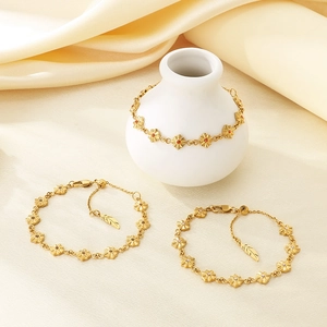 Elegante bracciale a maglie a fiori dorati con pietre portafortuna su sfondo seta