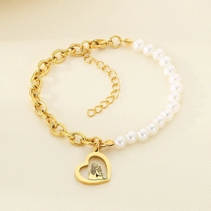 Detail of gold chain and pearl bracelet with heart-shaped mother and child pendant