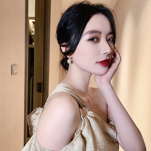 Boucles d'oreilles vintage cerclées d'or avec pierre œil de chat portées par un mannequin