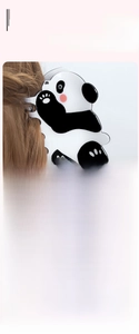 Detail view of a cute panda hair claw clip styled on a brunette ponytail