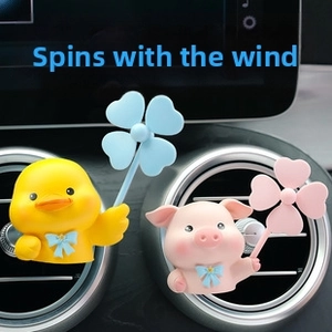 Close-up of cute cartoon duck and pig air vent clips with spinning heart fans in a car