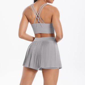 Detailed back view of a grey pleated tennis skirt and multi-strap sports bra set