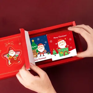 Christmas gift box with gold foil star cutout and festive cartoon greeting cards