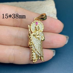 Detailed close-up of a 15x38mm gold Saint Jude pendant with cubic zirconia and red gem
