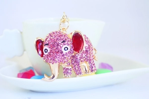 Macro detail of elephant keychain with sparkling pink rhinestones on a gold metal base