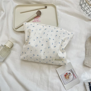 Floral makeup bag with blue flowers on white canvas featuring a Sozakka brand label