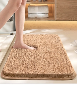 Macro detail of soft beige plush bathroom mat with feet showing cozy non-slip texture