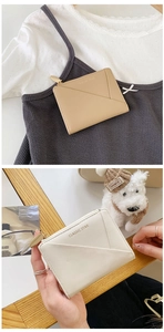 Detail of minimalist short leather wallet featuring card slots and a textured zipper