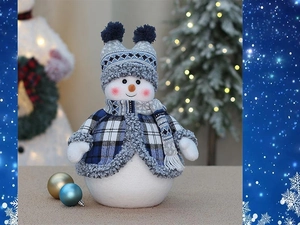 Dettaglio di un pupazzo di neve di peluche con abito scozzese blu e decorazioni