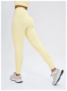 Detail of high waisted yellow yoga leggings with seamless texture and butt lift design