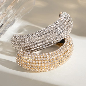 Classic 18k gold and silver U-shaped earrings with full crystal pavé on light surface