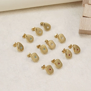 Detailed view of gold geometric stud earrings with inlaid red, blue and white crystals
