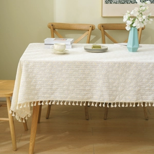 Beige cotton linen tablecloth with white daisy floral patterns and fringed edges