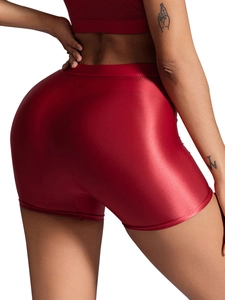 Dettaglio macro dei pantaloncini sportivi rossi lucidi a vita alta con finitura metallizzata