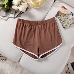 Brown athletic shorts with white piping on a grey fabric sofa with floral accents