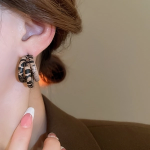 Close-up of leopard print multi-layer hoop earrings worn to show style and size